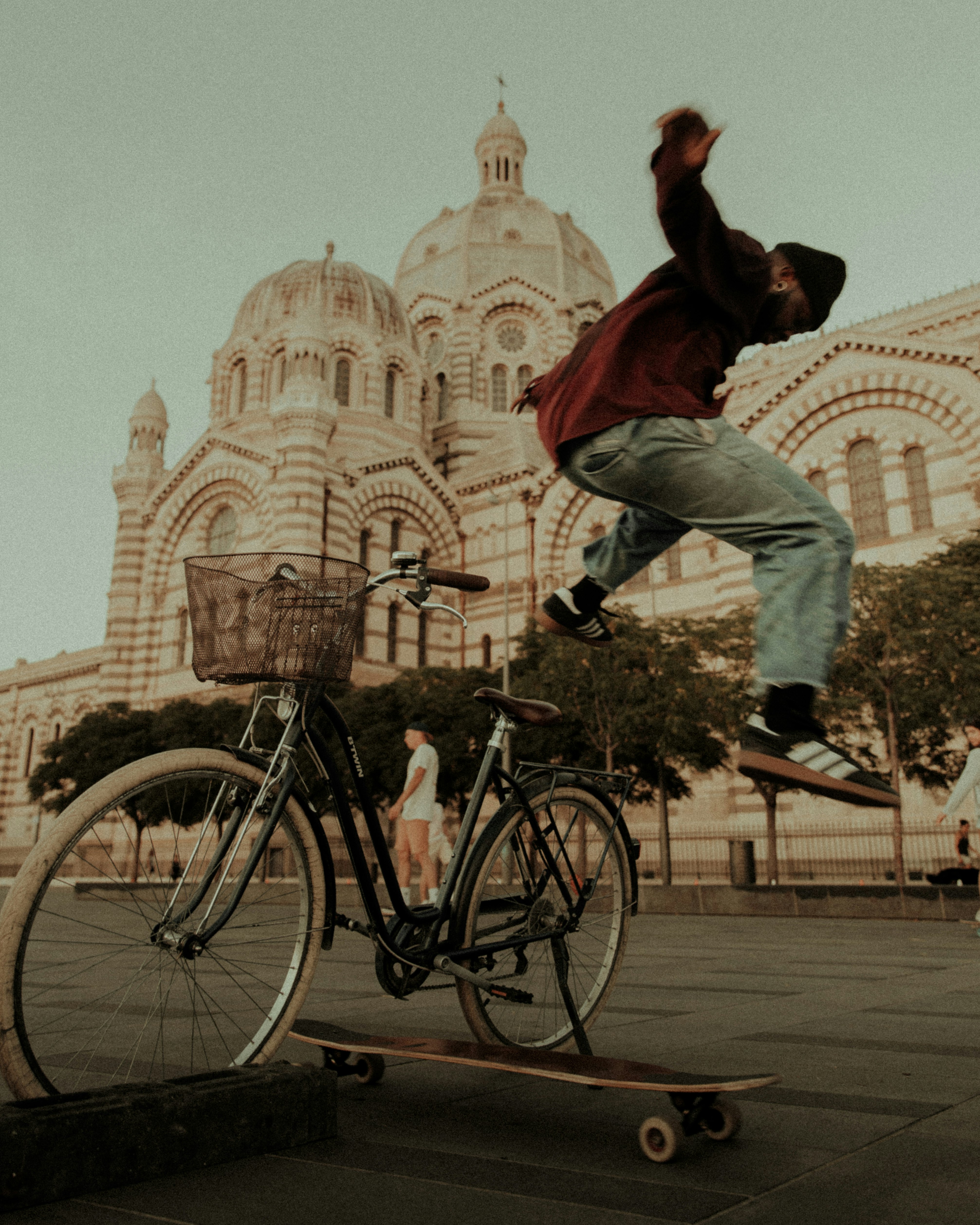 man in red shirt and blue denim jeans riding on black city bicycle